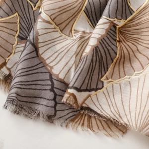 Detail of soft cotton linen scarf with metallic gold ginkgo leaf prints and frayed edges