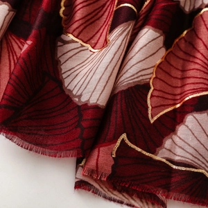 Macro shot of ginkgo leaf print on soft cotton linen shawl with gold foil edges