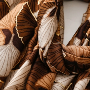 Detail of soft fabric with golden gingko leaf print and metallic outline craft