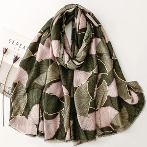 Detail of soft pashmina shawl with golden ginkgo leaf prints and pink green stitching