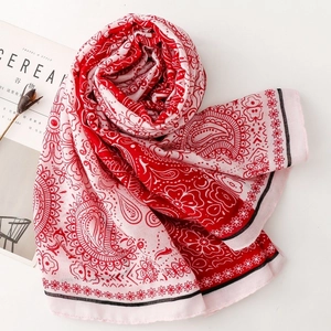 Detail of red and pink paisley pattern shawl with floral textures and soft silk fabric
