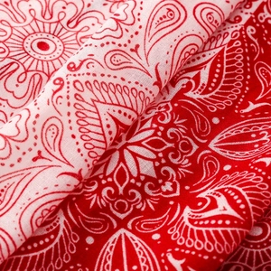 Macro detail of red and white paisley pattern print on soft lightweight scarf fabric