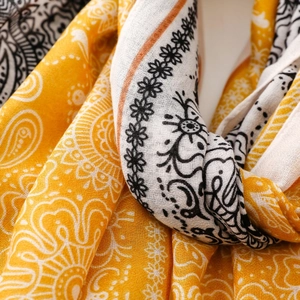 Close-up of yellow and white paisley pattern shawl with fine textile texture and draping