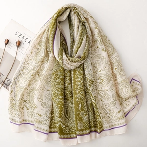 Detail of green and beige paisley patterned shawl with elegant ethnic floral textures