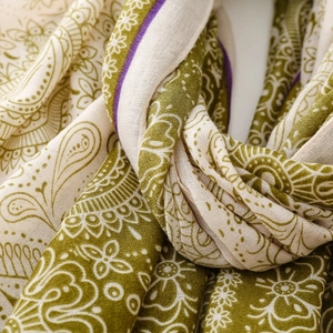 Detailed macro view of bohemian paisley print scarf in olive green and purple cotton fabric