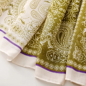 Macro detail of paisley pattern scarf showing soft cotton linen texture and olive green tones