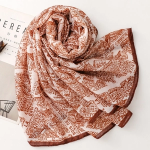 Detail view of retro map print on lightweight beige silk scarf with artistic patterns