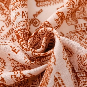 Macro shot of retro hand-painted architectural print on soft cream and brick red scarf