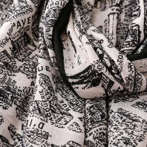 Detailed macro view of cream scarf with black architectural print and fine textile texture