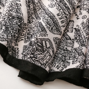 Close-up of retro French silk scarf featuring city map prints and fine fabric texture