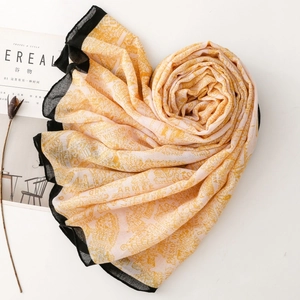Detailed view of folded silk scarf with heart shape and artistic letter prints