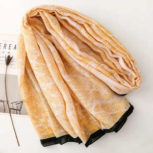Detail of printed scarf with vintage map pattern and black border on pink fabric