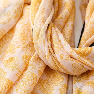 Detailed macro view of soft peach silk scarf with French street names and elegant architecture