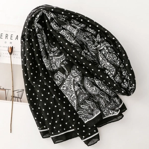 Detailed flat lay of black and white scarf with paisley and polka dot patterns