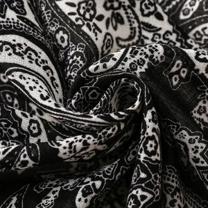 Macro shot showing soft black and white paisley floral pattern fabric texture