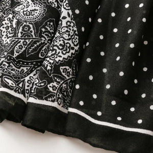 Detail of black and white scarf featuring paisley patterns and small polka dot textures