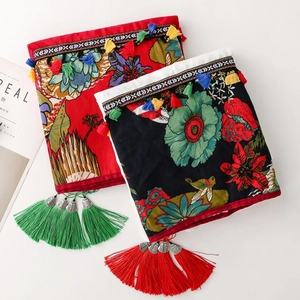 Close-up of ethnic embroidered pouches with floral bird patterns and large tassels