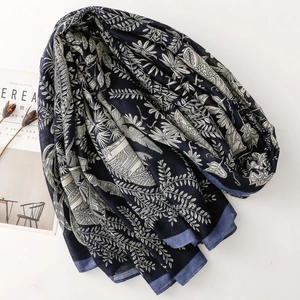 Close-up of navy blue floral scarf with elegant plant prints and soft wrinkled texture