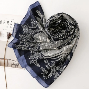 Macro detail of navy blue scarf with white leaf patterns and soft woven texture