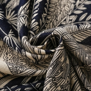 Close-up of cotton-linen scarf fabric featuring blue and white plant leaf patterns