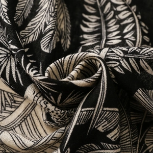 Detailed texture of cotton linen scarf featuring black and white tropical leaf patterns