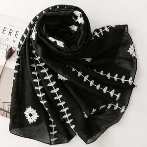 Detailed embroidery on a black ethnic style scarf with leaf and floral patterns