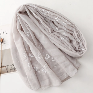 Close-up of lightweight lavender linen scarf with white floral embroidery and soft texture
