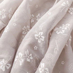 Close-up of soft floral pattern on lightweight pink linen shawl with dot details