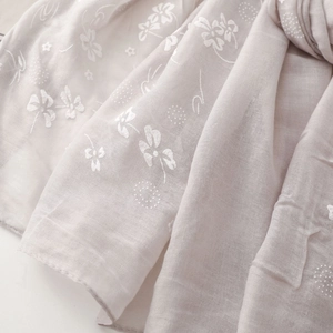 Close-up of lightweight cotton linen scarf showing delicate white floral embroidery
