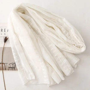 Detail showing the leaf embroidery texture and fine fabric of this white cotton shawl