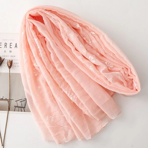 Detail of peach cotton linen scarf with floral butterfly embroidery and soft texture