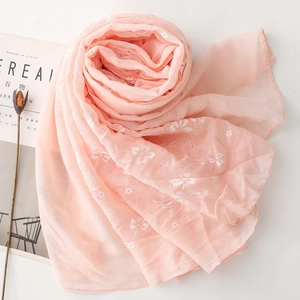 Close-up of light pink cotton linen scarf with delicate white floral embroidery details