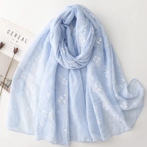 Light blue floral cotton linen scarf for women with white flower prints on a minimalist desk