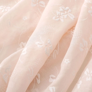 Close-up of lightweight linen cotton fabric with white floral embroidery for scarves