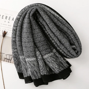 Detail shot of black and white textured knit scarf with elegant accordion pleat edges