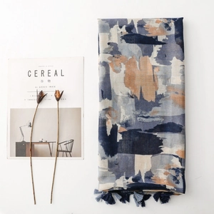 Detailansicht eines Schals mit Ölgemälde-Print und eleganten Quasten auf weißem Grund
