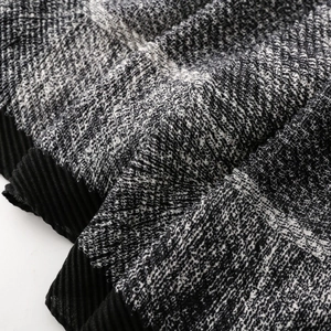 Macro view of textured heather knit fabric with fine pleats and black pleated edges