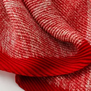Macro detail of red and white woven textured knit scarf with pleated vertical edges