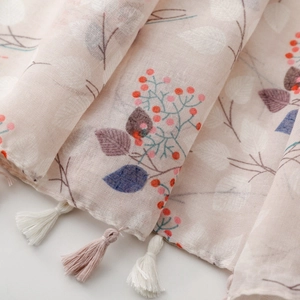 Detailed macro shot of floral print scarf fabric with soft tassels and berry patterns