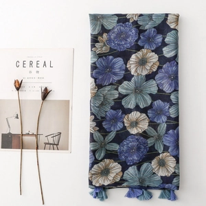 Detail of blue floral print scarf with soft tassels and artistic flat lay lifestyle props