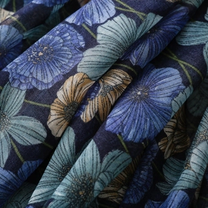 Macro shot of floral patterns and woven texture on blue tassel scarf fabric