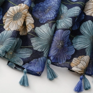 Close-up of bohemian blue floral print scarf showing detailed fabric and tassels