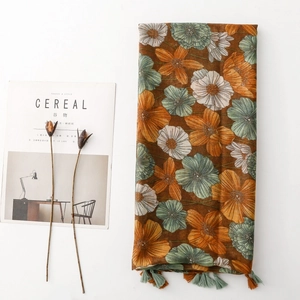 Detail of floral printed scarf with tassels, vintage daisy patterns and linen texture