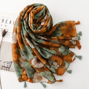 Detailed shot of retro floral print scarf with intricate green and orange fringe tassels