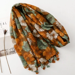 Detail view of vintage floral print scarf with soft fringe tassels in warm orange tones