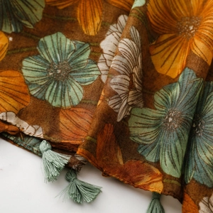 Close-up of vintage floral print scarf with blue tassels and orange poppy patterns