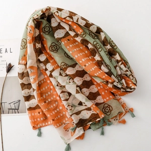 Bohemian geometric floral scarf with tassels shown with a magazine and dried flower