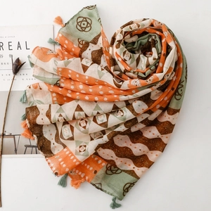 Detail of bohemian geometric print scarf with colorful tassels and soft fabric texture