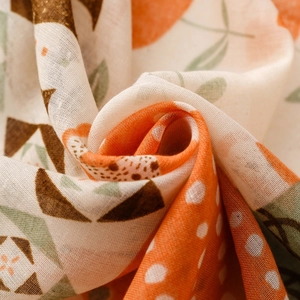 Close-up of soft muslin scarf featuring vibrant bohemian floral and geometric prints