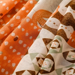 Close-up of bohemian printed scarf showing orange polka dots and geometric floral texture